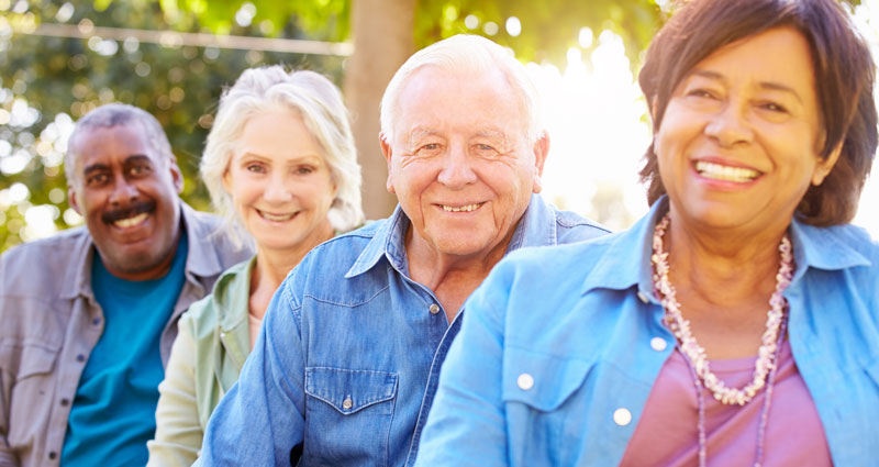four seniors smiling outdoors
