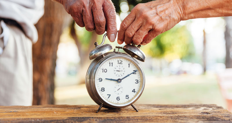 two seniors holding an alarm clock