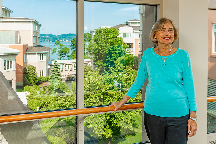Smiling woman in a walkway with view of the Hudson River.