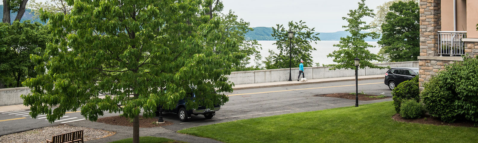 Woman walking small dog on the grounds of Kendal on Hudson