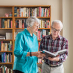Two senior residents looking over information in a book