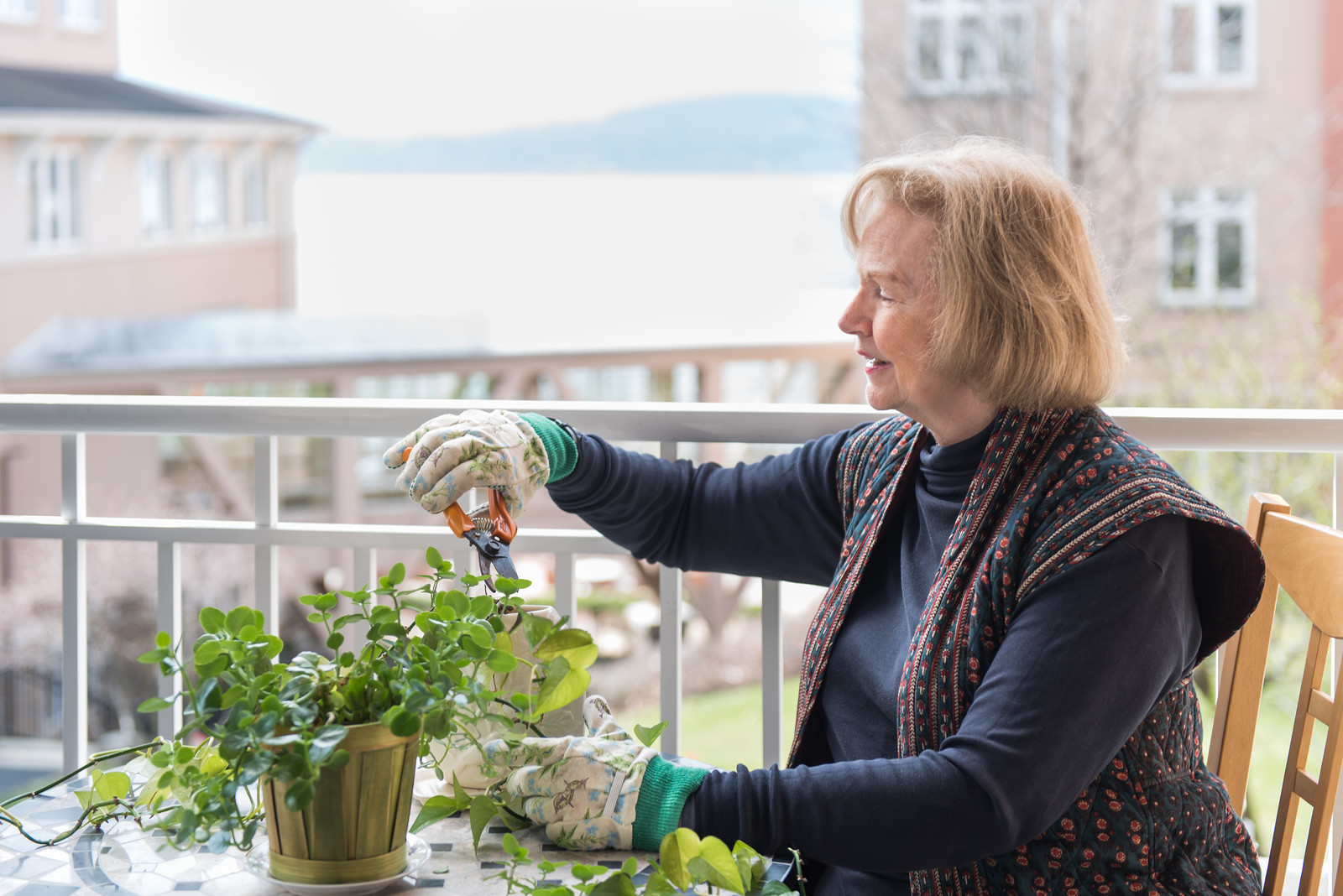 Resident pruning plant on her balcony