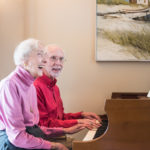 Two residents sitting at the piano