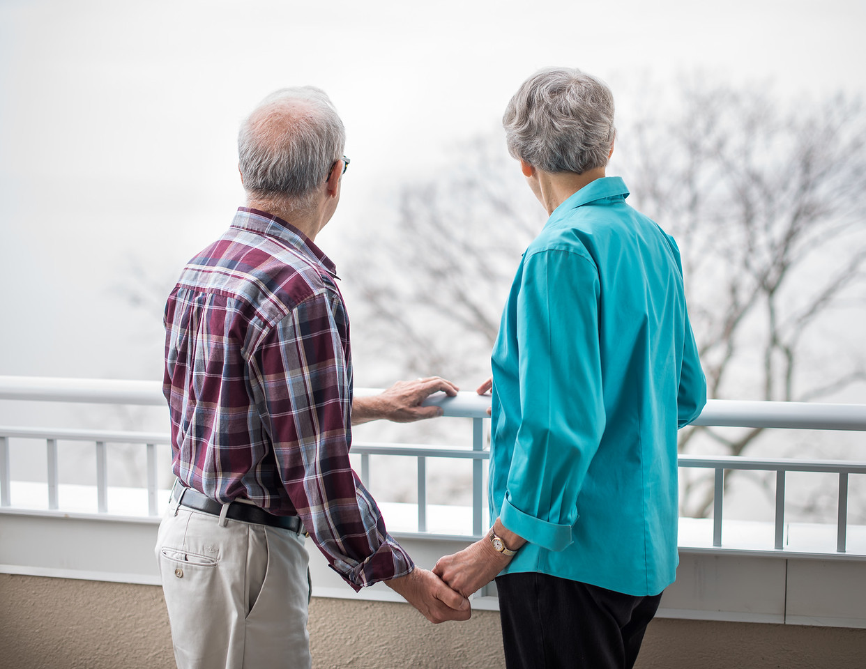 Couple holding hands looking out on a winter day