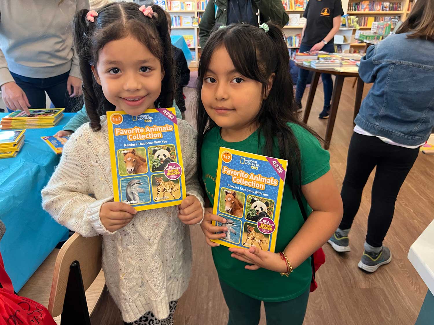 Two young girls holding books to the camera