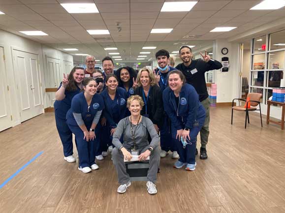 staff members huddled together for a group photo in the fitness center