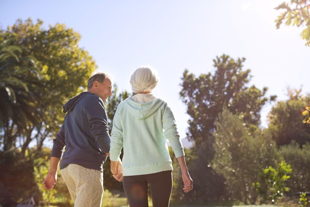 senior couple taking a walk outside while holding hands