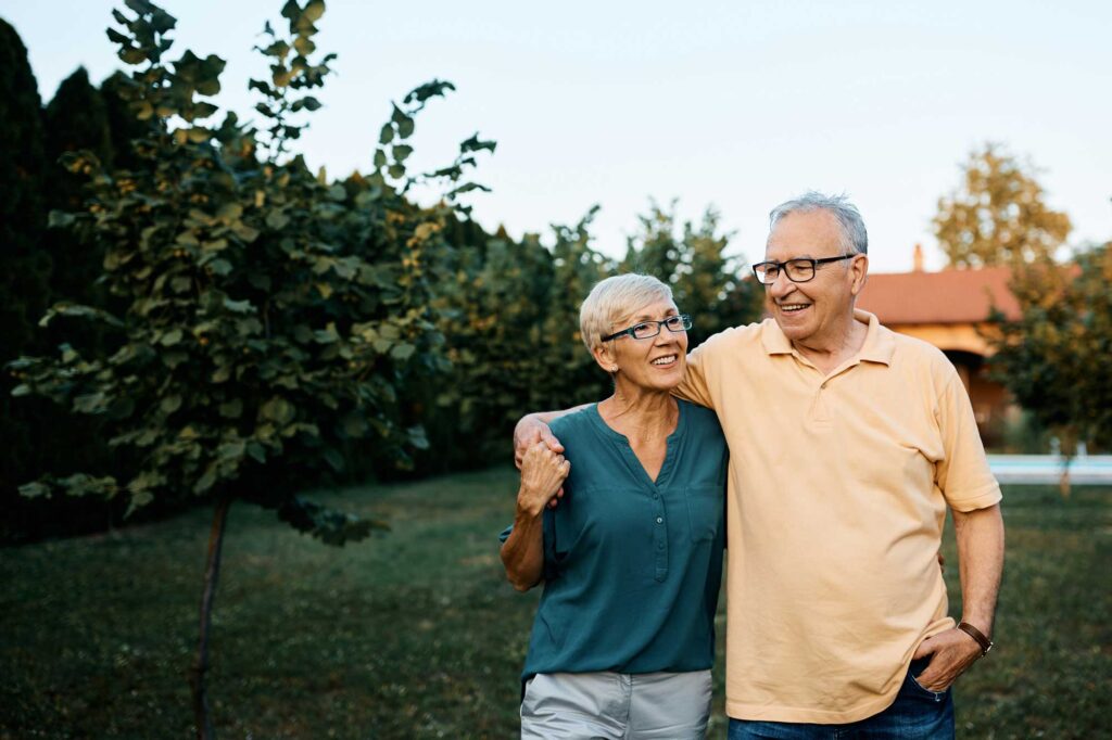 senior couple walking outside at sunset