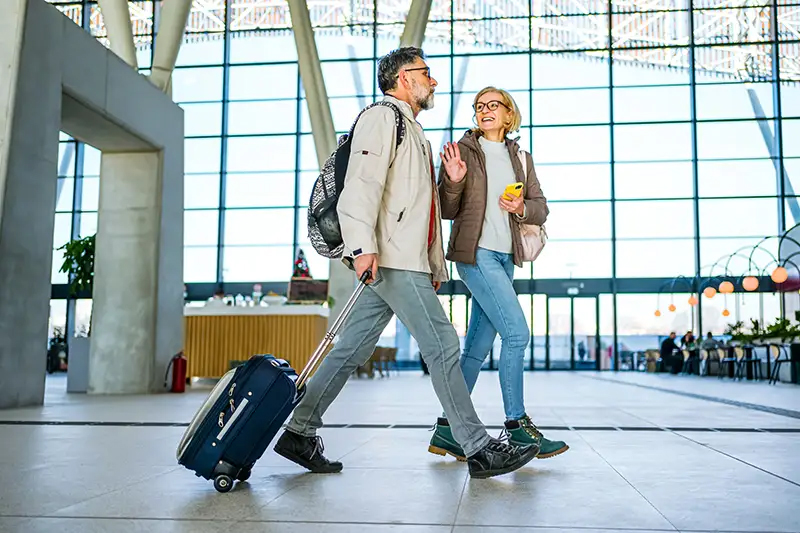 Senior couple talking while walking through the airport
