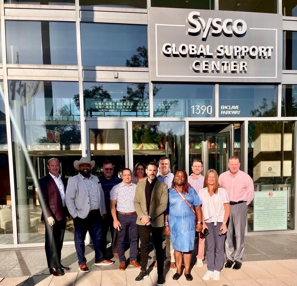 Group of professionals standing outside the Sysco Global Support Center building