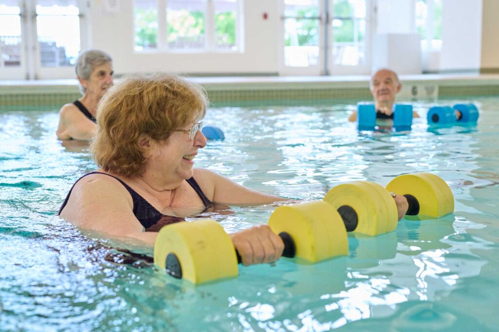 seniors lifting weights in an indoor pool