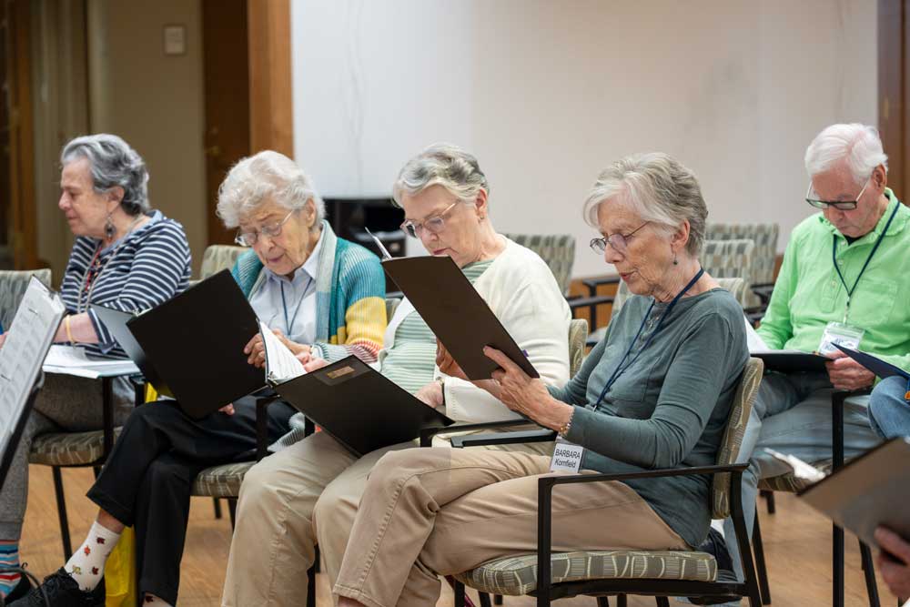 a group of Kendal on Hudson residents reading sheet music together