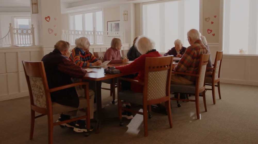 a group of Kendal on Hudson residents sitting at a table chatting